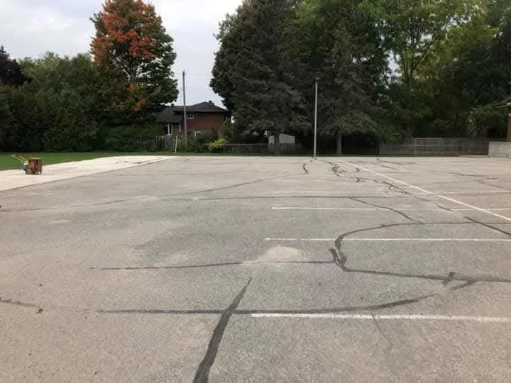 Cracked asphalt surface condition before repair review.