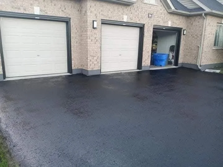 Fresh sealcoat near residential garage doors.
