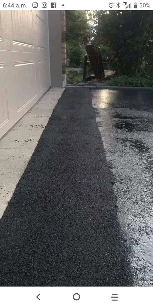 Vertical detail photo of fresh sealer along an asphalt edge.