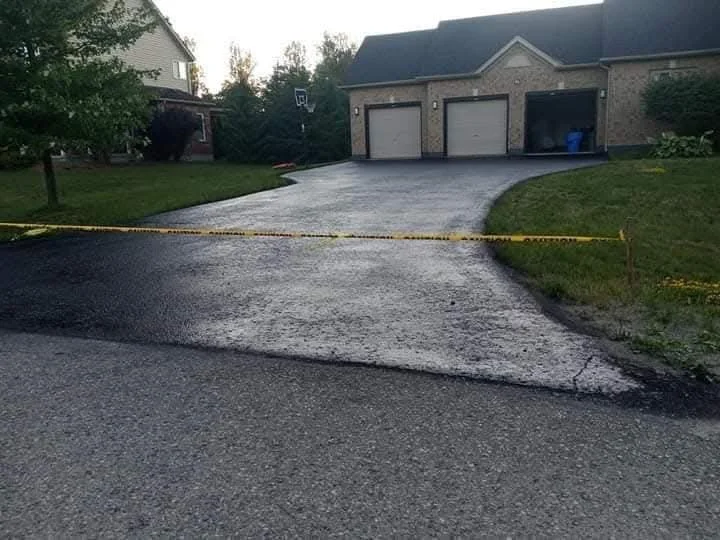 Fresh sealed driveway across a triple garage frontage.