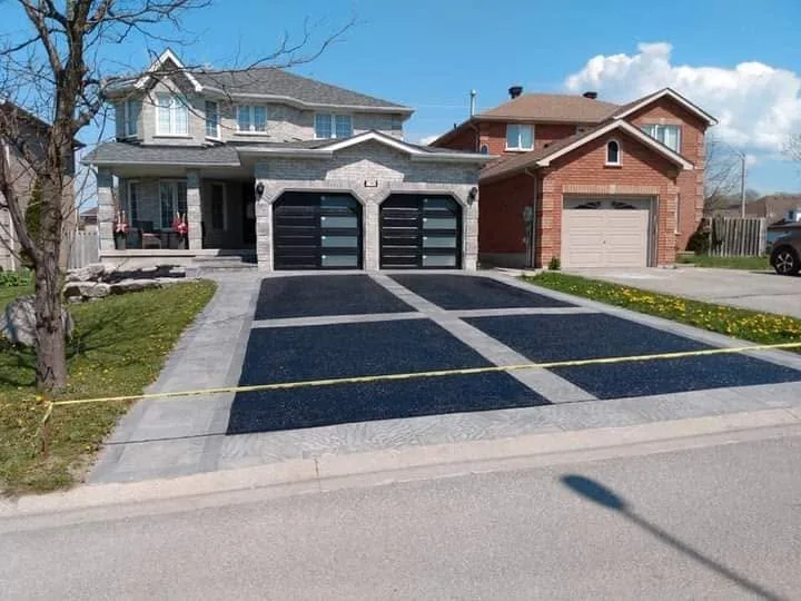 Fresh sealed driveway in front of a residential garage.